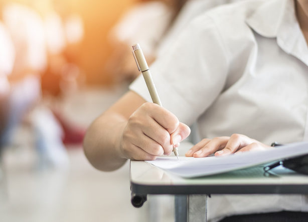 Exam with school student having a educational test, thinking hard, writing answer in classroom for university education admission and world literacy day concept